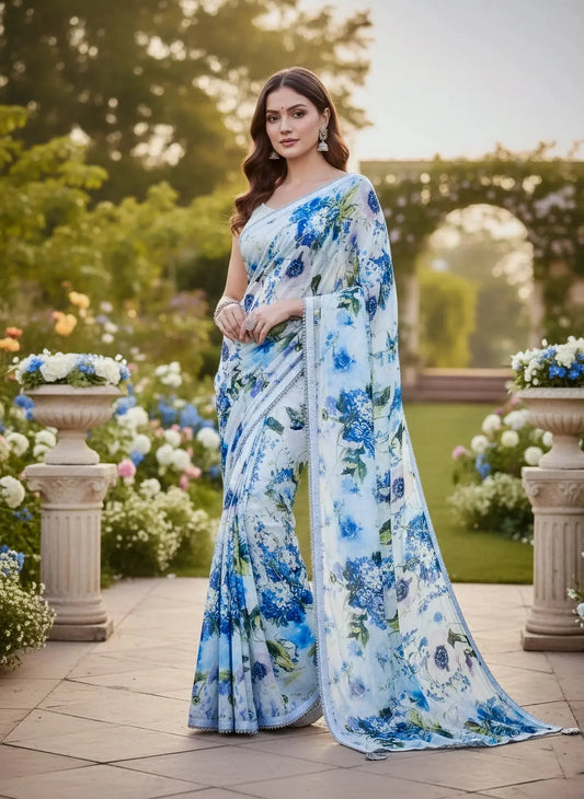 Woman in a blue floral soft silk saree posing in a lush garden surrounded by flowers