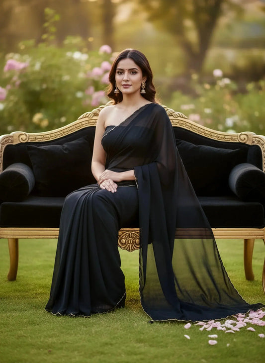 Woman in black silk saree with gold earrings sitting on ornate sofa outdoors