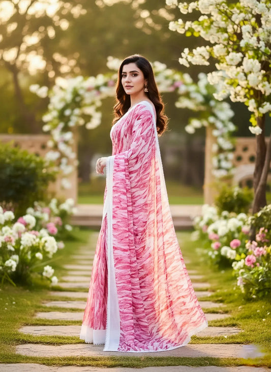 Woman in elegant pink and white soft silk saree posing outdoors among blooming flowers