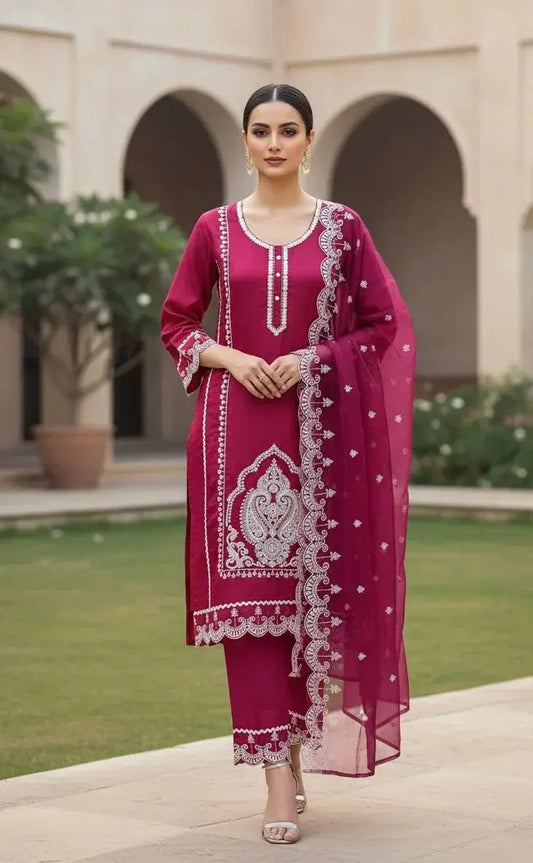 Woman in magenta embroidered ethnic suit with matching dupatta, standing outdoors