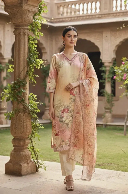 Woman in an elegant pastel floral silk salwar kameez with dupatta, standing in a courtyard