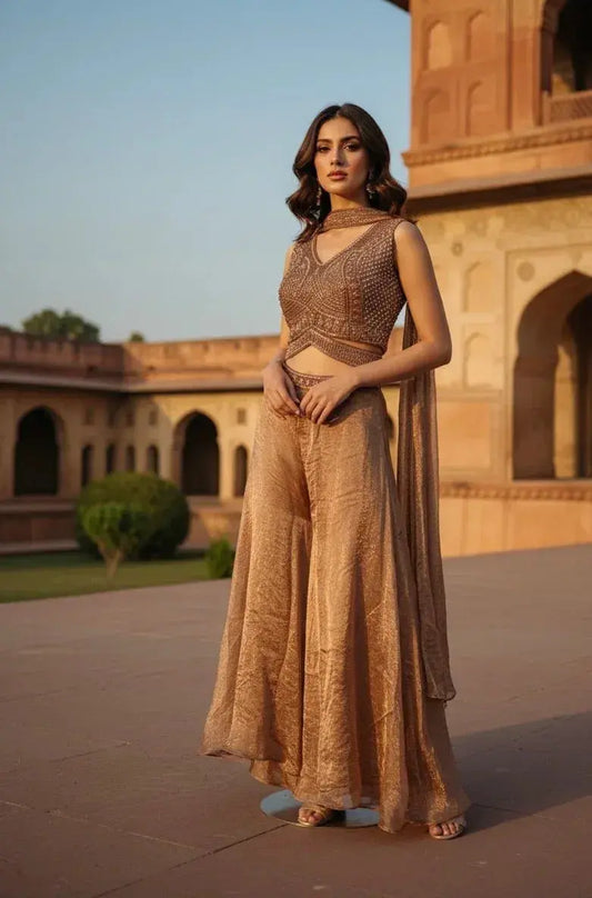 Woman wearing a brown embroidered ethnic crop top and wide-leg palazzo pants in a heritage courtyard