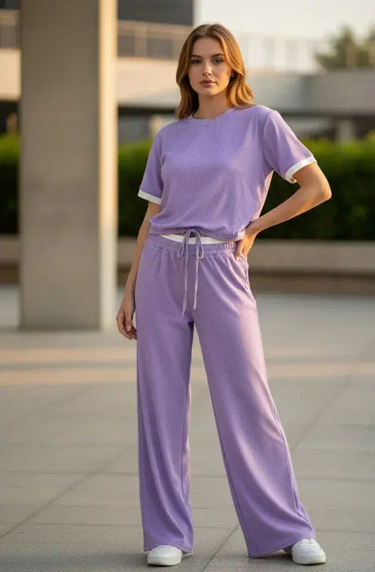 Woman wearing lilac loungewear set with short sleeves and wide-leg pants outdoors