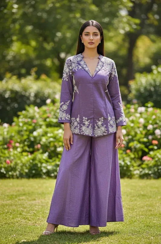 Woman in a lavender ethnic co-ord set with white embroidery, standing outdoors in a garden