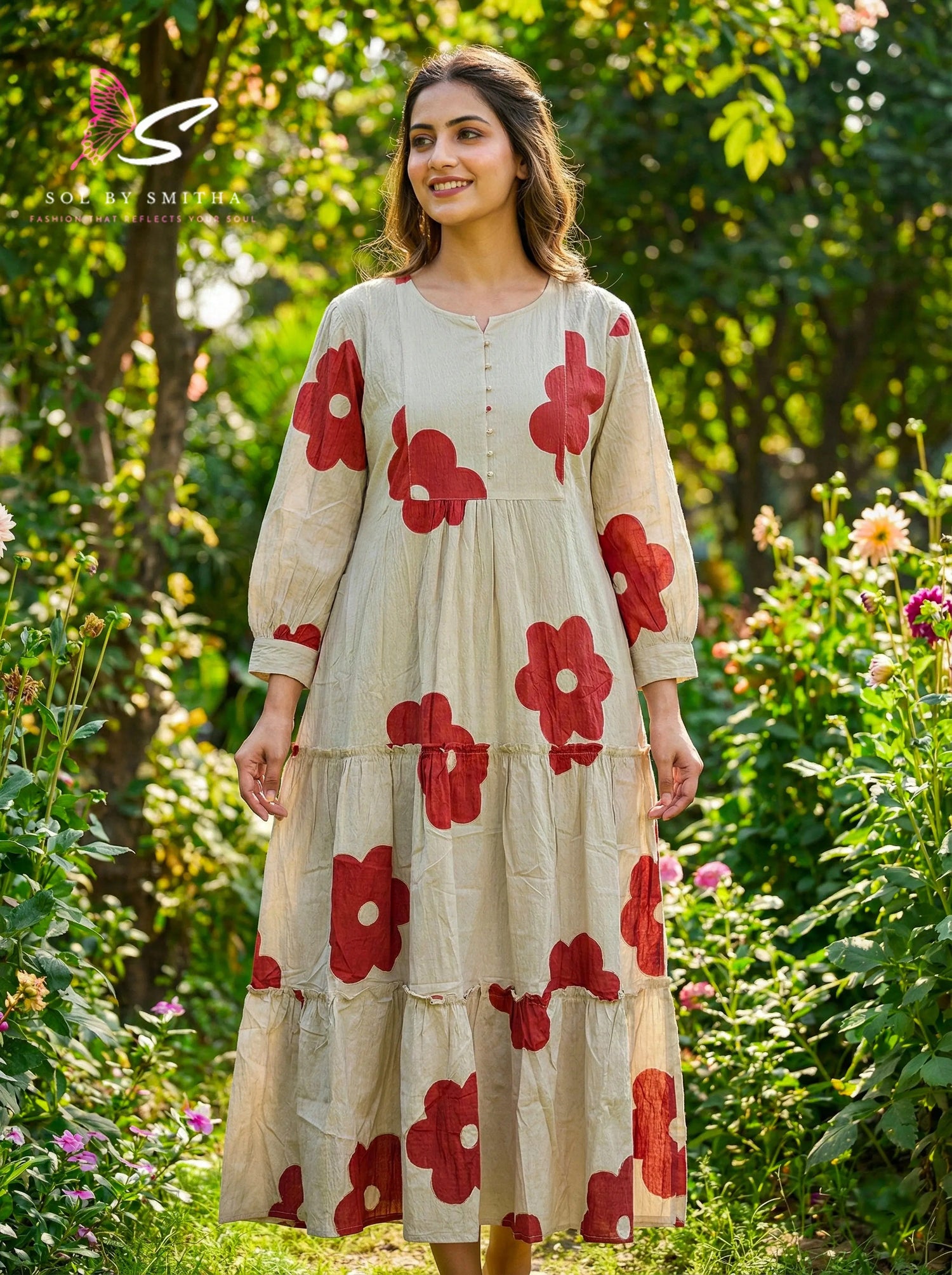 Woman wearing a beige maxi dress with bold red floral prints, standing in a lush garden-74