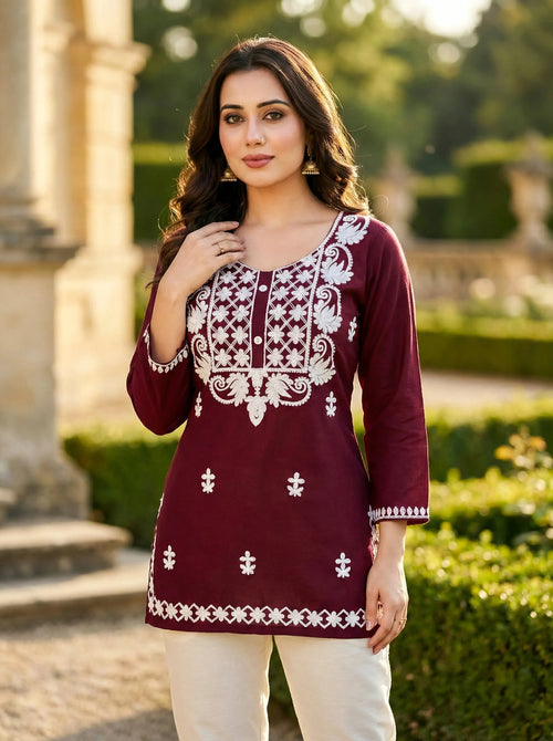 Woman wearing maroon embroidered kurta with white floral patterns, outdoor setting