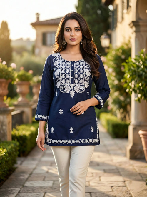 Woman in blue embroidered kurti and white pants walking outdoors in ethnic wear
