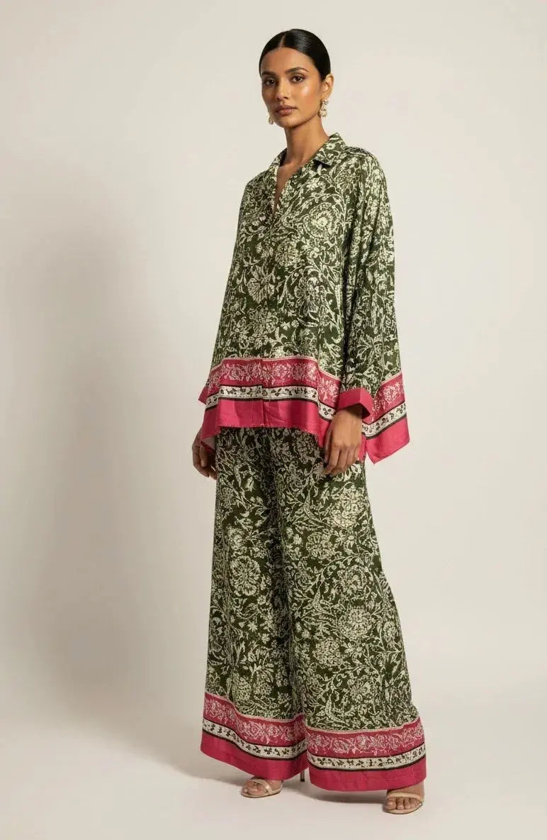 Woman wearing green floral ethnic set with pink border, loose kurta and wide-leg pants