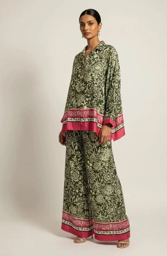 Woman wearing green floral ethnic set with pink border, loose kurta and wide-leg pants