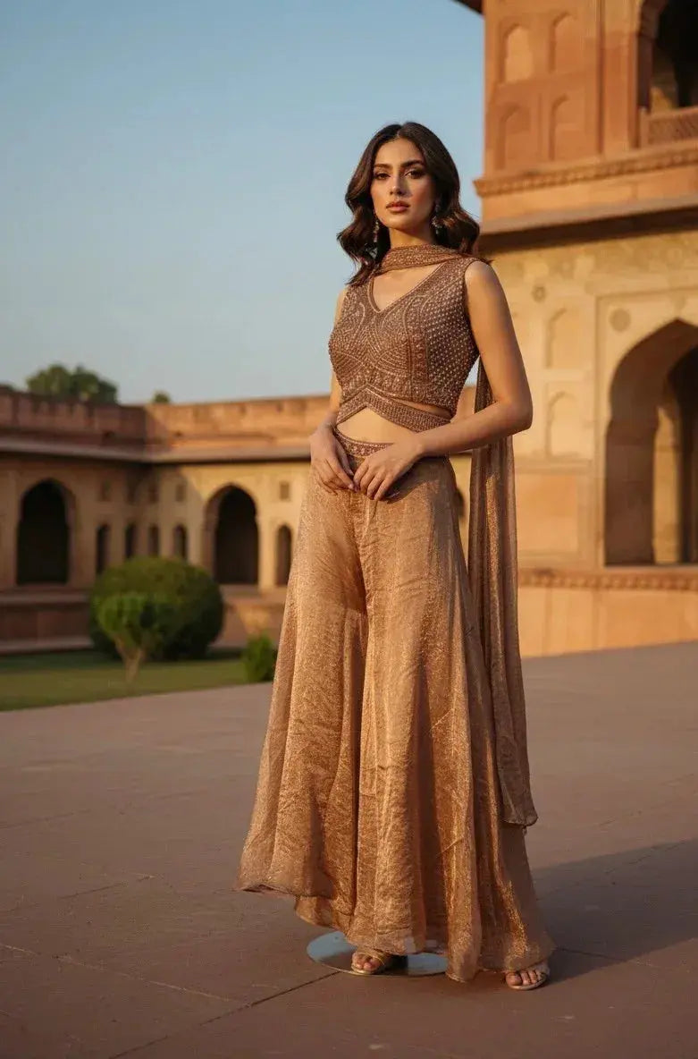 Woman wearing a brown embroidered ethnic crop top and wide-leg palazzo pants in a heritage courtyard