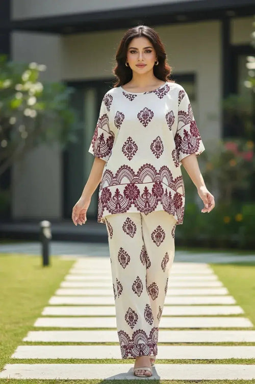 Woman wearing cream and maroon printed ethnic co-ord set, walking outdoors on a pathway