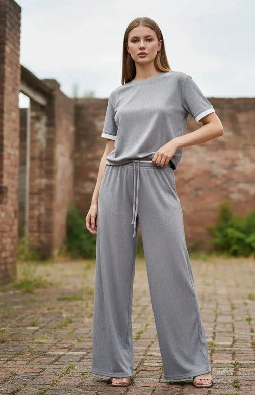 Woman wearing a grey loungewear co-ord set with drawstring wide-leg pants outdoors