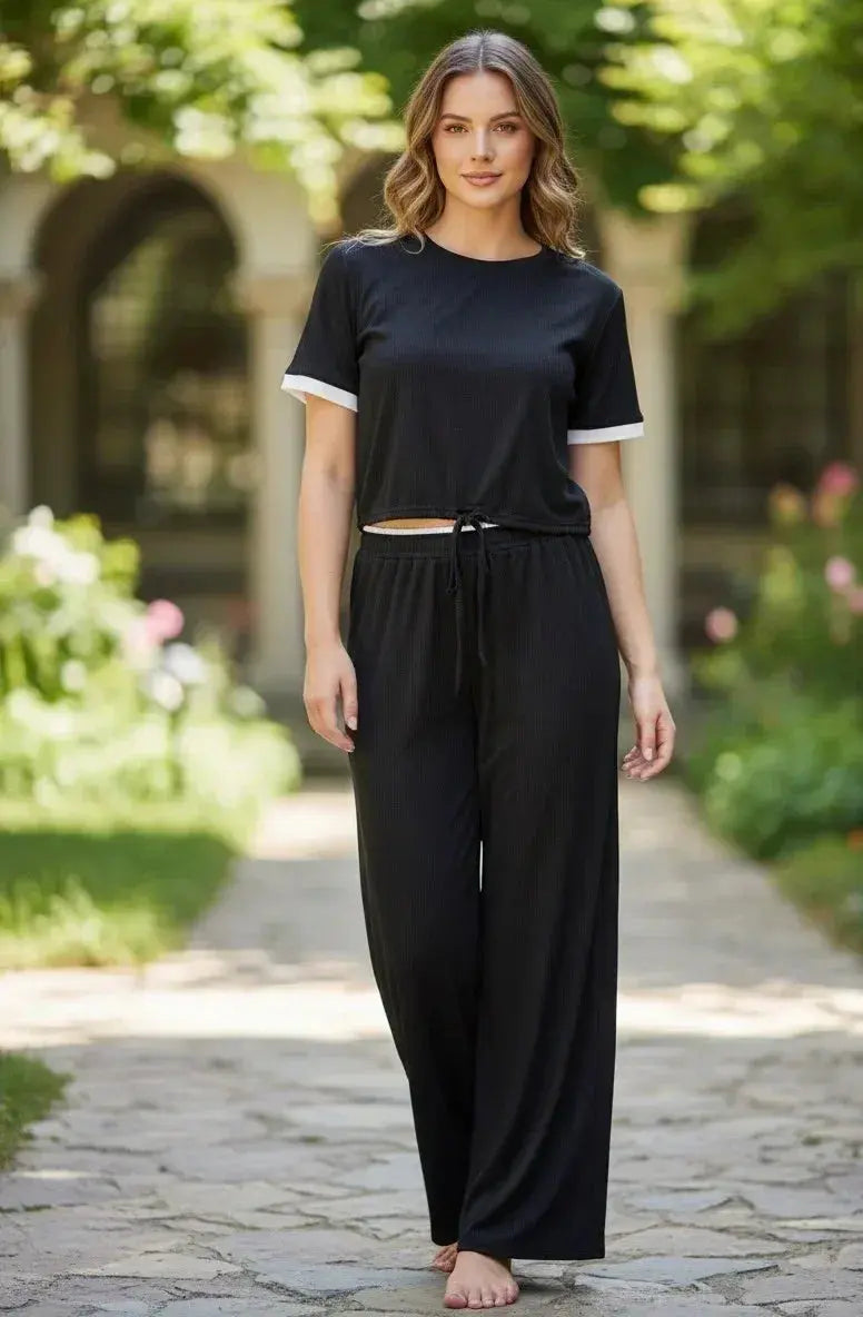 Woman outdoors wearing black loungewear set with white sleeve trim, relaxed fit