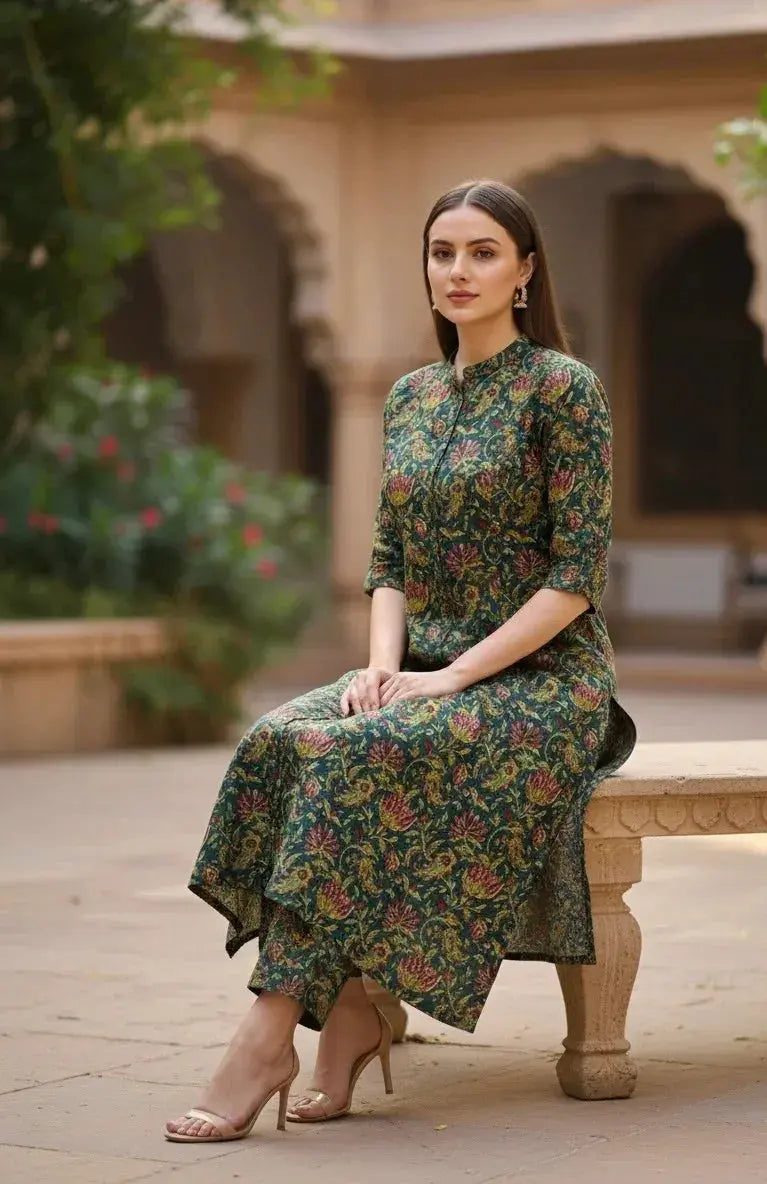 Woman in a green floral printed silk ethnic kurta set seated outdoors, elegant festive wear