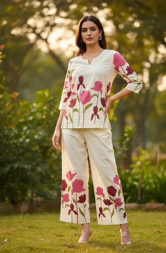 Woman wearing cream floral embroidered ethnic set with wide-leg pants in a garden