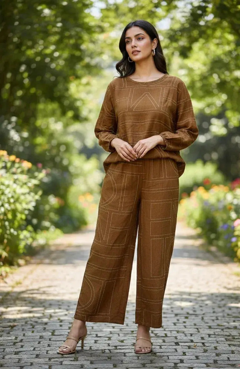 Woman wearing a brown printed co-ord set with long sleeves and wide leg pants, outdoor garden