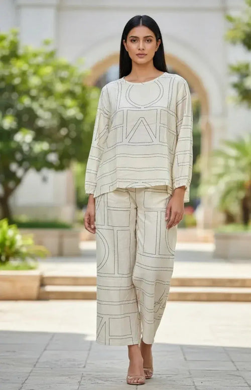 Woman wearing cream geometric print ethnic co-ord set, outdoor garden background