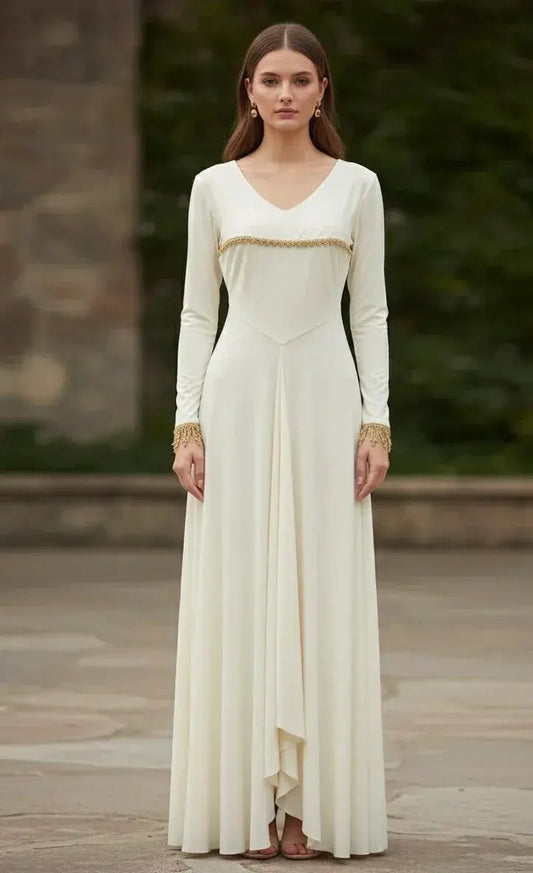 Woman wearing a long ivory ethnic gown with gold trim, long sleeves, and flared hem